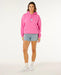 Rip Curl pink surf hoodie with front logo, worn by woman in denim shorts and white trainers
