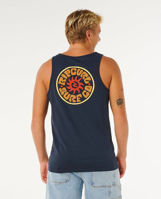 Rip Curl dark navy tank vest with retro surf logo on back, worn by man in denim shorts