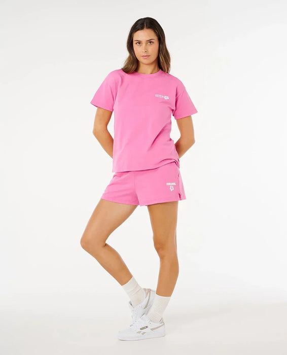 Rip Curl women's surf puff shorts and t-shirt set in bright pink, lifestyle photo