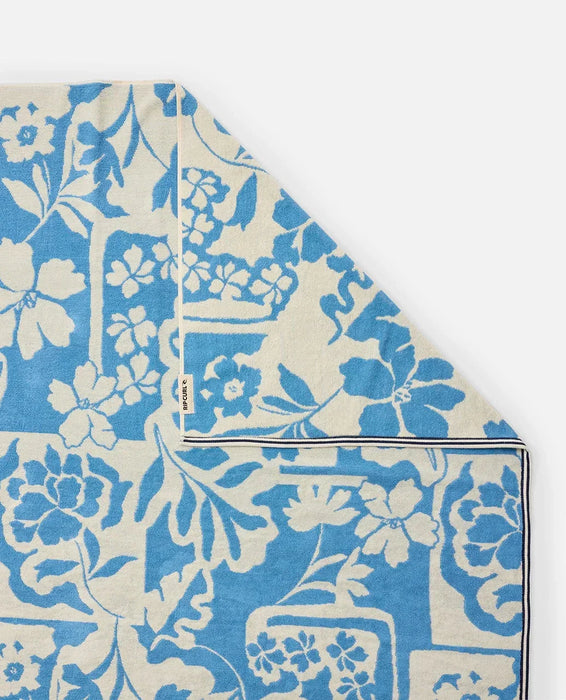 Rip Curl surf towel in blissful blue with floral print and logo tag, beach accessory.