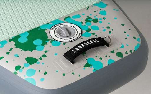 Sandbanks inflatable paddleboard with teal and green splatter design and textured deck pad