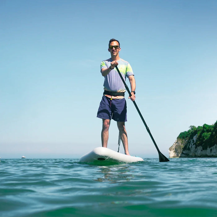 Paddler on a Sandbanks Ultimate Blue inflatable paddle board on calm water