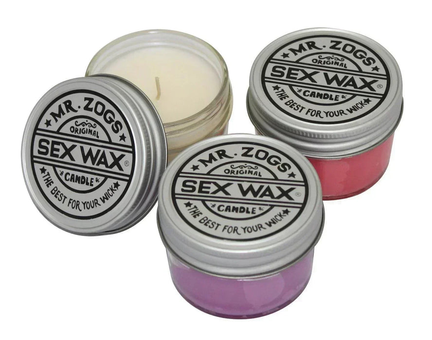 Mr. Zog's Sex Wax scented candles in tins, displayed in white, pink, and purple.