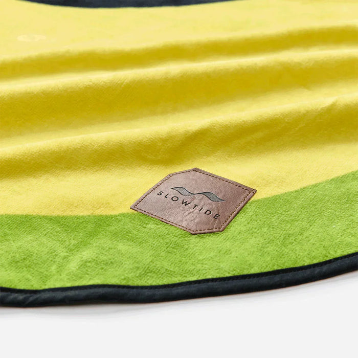 Slowtide beach towel with yellow and green stripes and logo patch visible