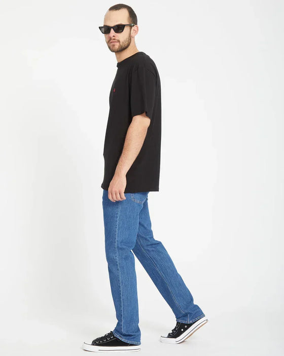 Volcom Solver jeans in bold blue, straight fit, modeled with black t-shirt and trainers