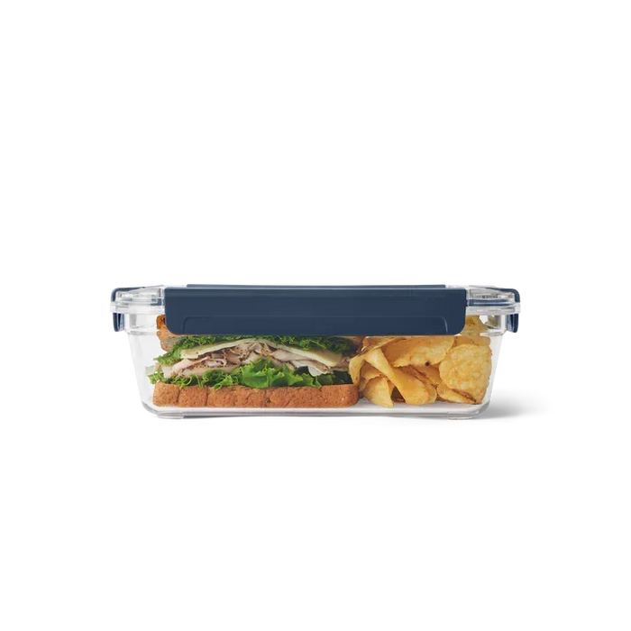 Yeti large food storage container with dark blue lid, holding sandwich and crisps